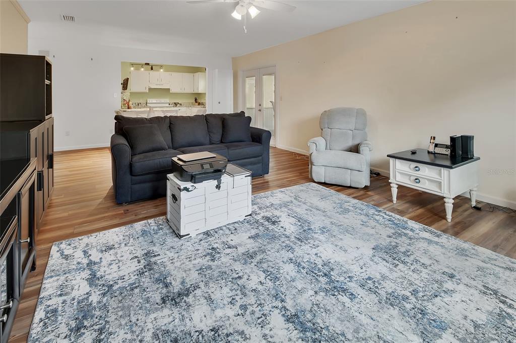 A living room with a dark sofa, light recliner, and a large blue patterned rug — 720 S HILL AVENUE UNIT 8B, DELAND, FL