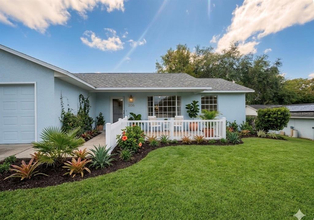 A light blue single-story house features a white picket fence and a landscaped front yard — 36422 BIRDIE COURT, GRAND ISLAND, FL