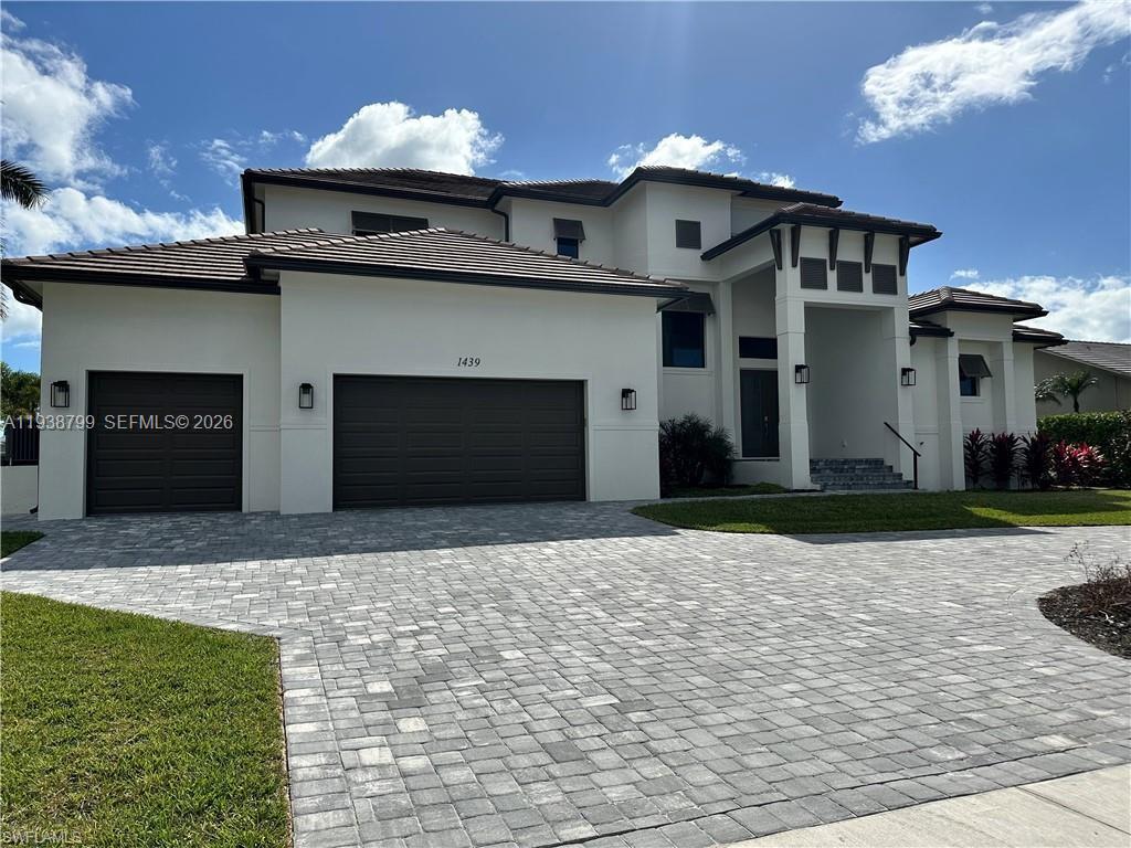 A two-story house with a paved driveway, a three-car garage, and a covered entryway — 654 Bamboo Ct, Marco Island FL 34145, MARCO ISLAND, FL
