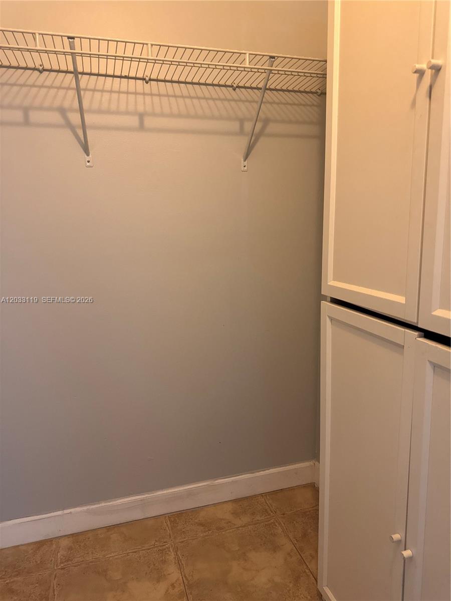 A closet features a wire shelf, light-colored walls, and a white cabinet unit — 14931 SW 82nd Ln # 403, Miami FL 33193, MIAMI, FL