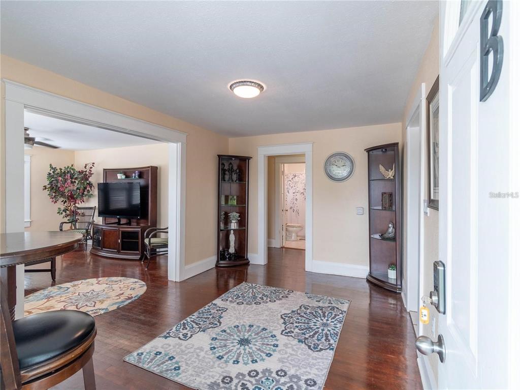 An entryway with hardwood floors leads to a living room and a bathroom — 103 E MOHAWK AVENUE UNIT B, TAMPA, FL