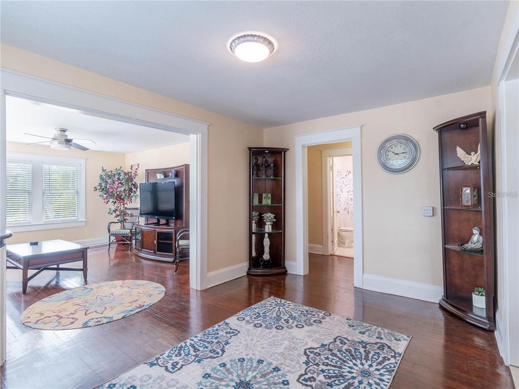 A living room with hardwood floors, a patterned area rug, and a doorway to another room — 103 E MOHAWK AVENUE UNIT B, TAMPA, FL