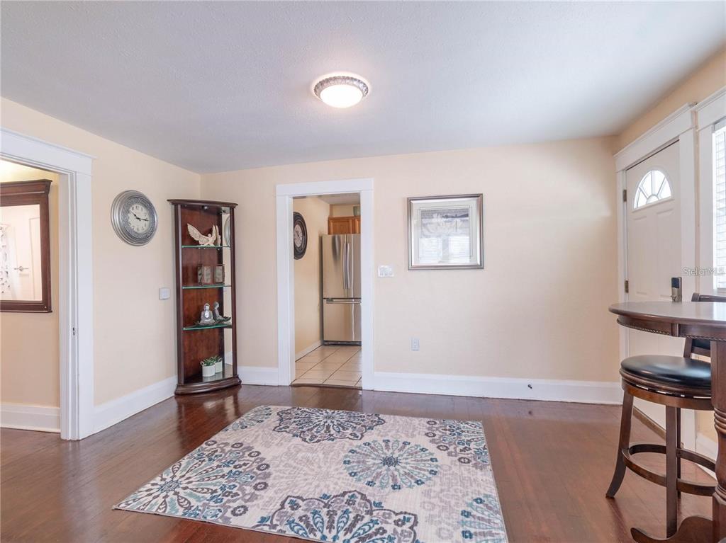 A dining area with hardwood floors, a patterned rug, a display cabinet, and a doorway — 103 E MOHAWK AVENUE UNIT B, TAMPA, FL