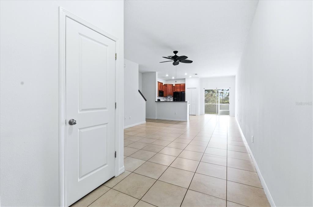 A view of a tiled living area leading to a kitchen with dark wood cabinets — 12909 DREAM CATCHER WAY, RIVERVIEW, FL