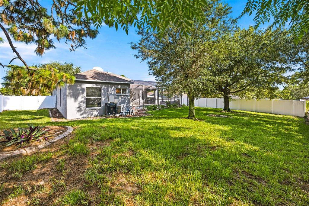 An aerial view shows several suburban houses with swimming pools and driveways surrounded by trees — 5517 GREYSTONE DRIVE, SPRING HILL, FL