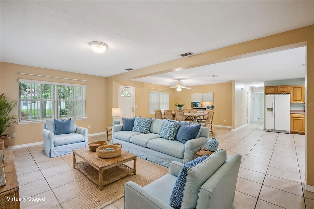 A living room with light blue furniture, tile flooring, and an open kitchen in the background — 1531 19TH STREET, ORANGE CITY, FL