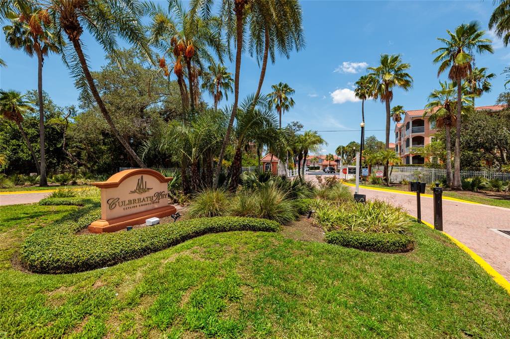 A sign for Culbreath Key stands in front of palm trees and a residential building — 5000 CULBREATH KEY WAY UNIT 4-105, TAMPA, FL