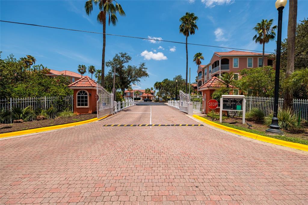 A gated entrance with a brick-paved road leads into a residential apartment complex — 5000 CULBREATH KEY WAY UNIT 4-105, TAMPA, FL
