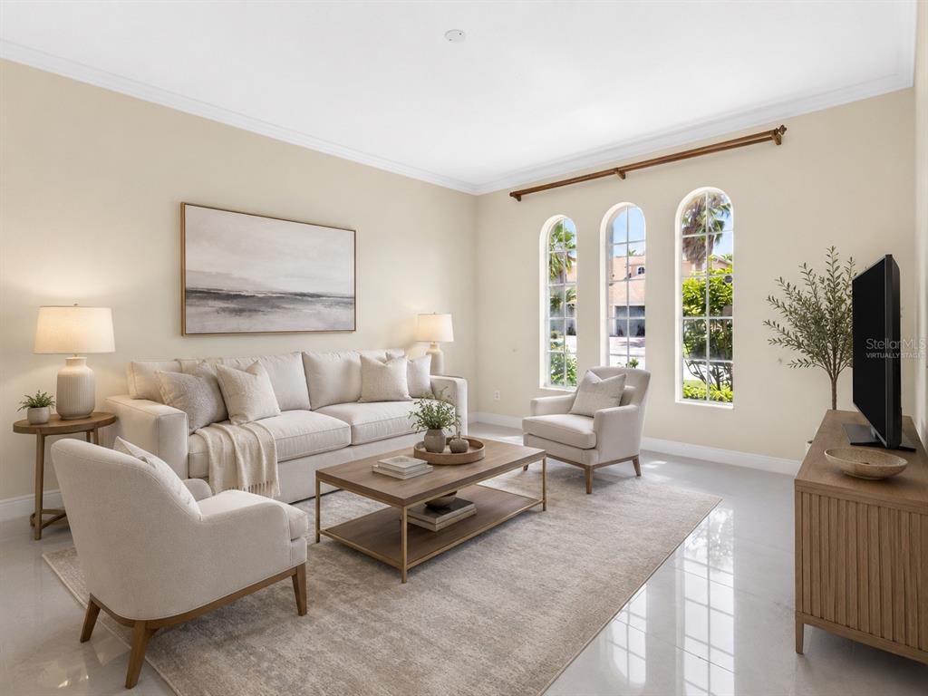 A living room features a beige sofa, two armchairs, a coffee table, and arched windows — 856 TIMBER ISLE DRIVE, ORLANDO, FL