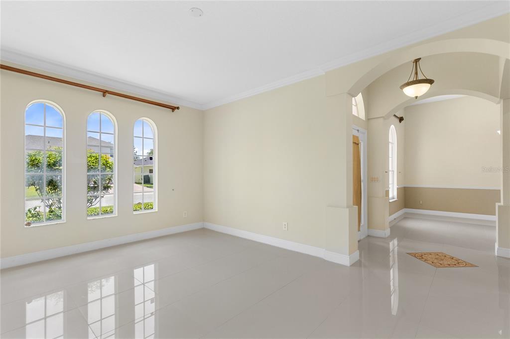 A bright room with light tile floors, three arched windows, and an arched entryway — 856 TIMBER ISLE DRIVE, ORLANDO, FL