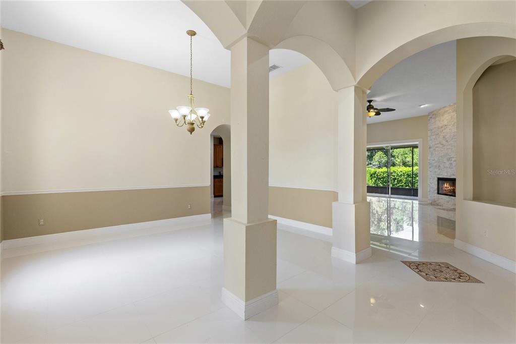 An open dining area features white tile floors, arched columns, and a chandelier — 856 TIMBER ISLE DRIVE, ORLANDO, FL