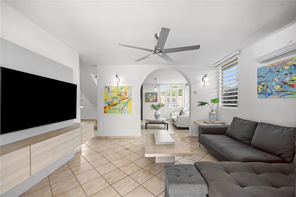 A living room features tile floors, a gray sectional sofa, and an arched entryway — Calle 6 H17 TINTILLO GARDENS, GUAYNABO, PR