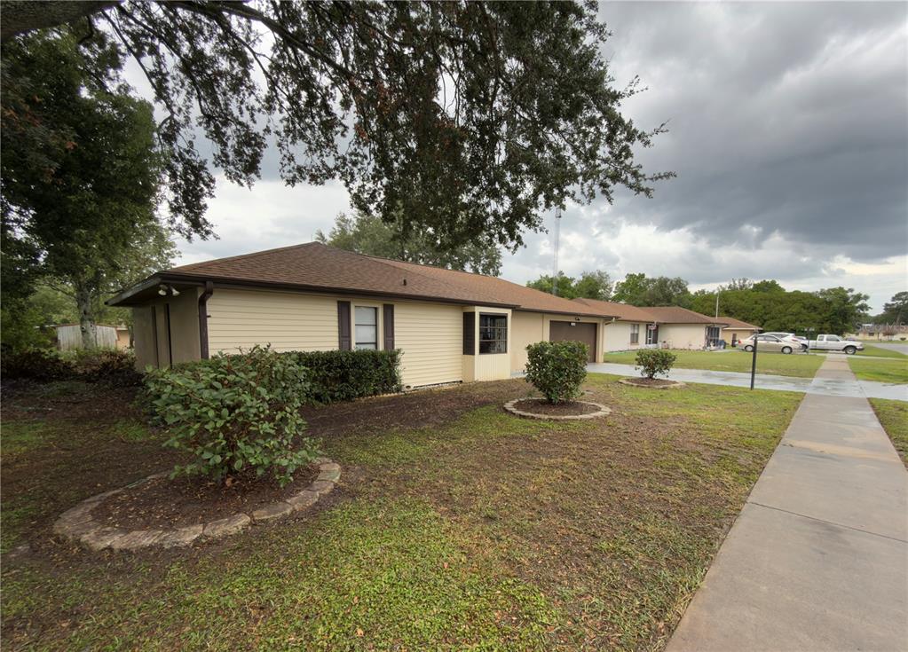 A single-story house with light yellow siding, a brown roof, and a front lawn — 15120 SW 35TH CIRCLE, OCALA, FL