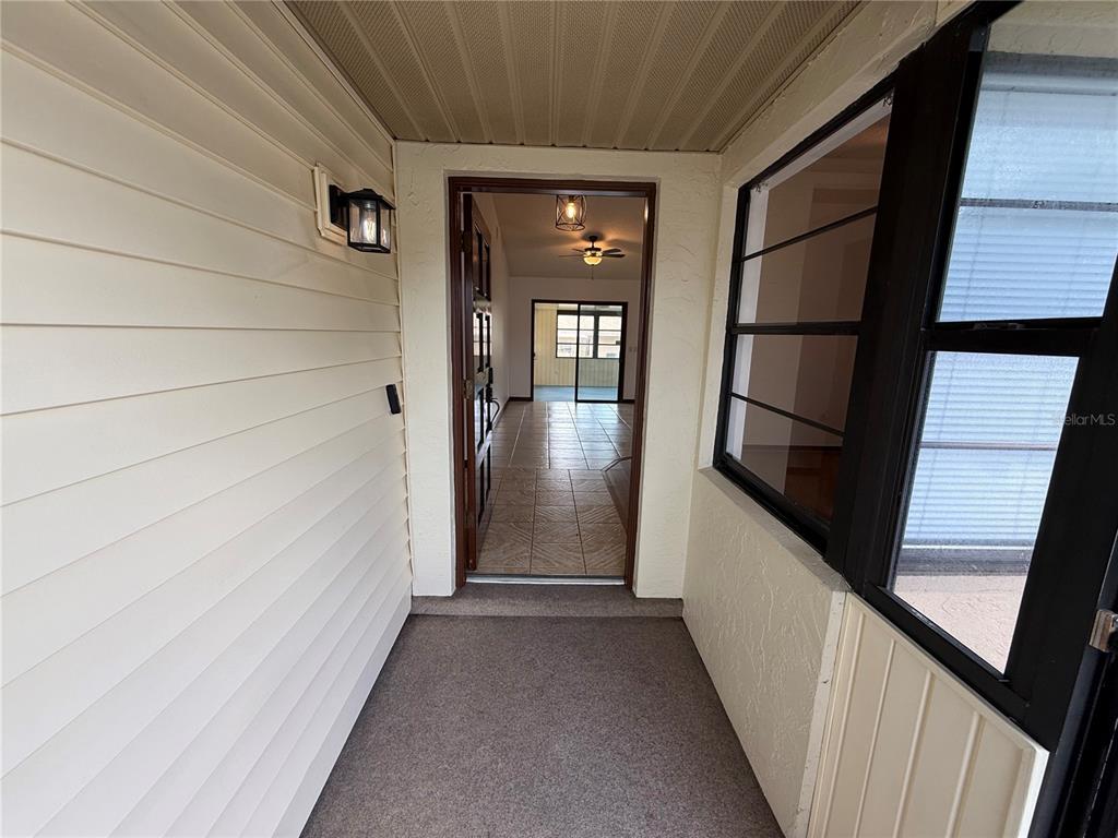 A covered entryway leads through an open doorway into a tiled interior living space — 15120 SW 35TH CIRCLE, OCALA, FL
