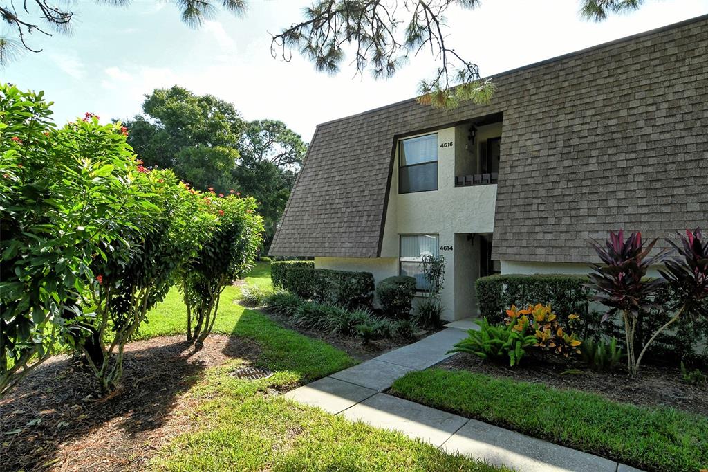 Exterior view of a two-story apartment building with shingled mansard roof and landscaped grounds — 4616 RINGWOOD MEADOW UNIT 20, SARASOTA, FL