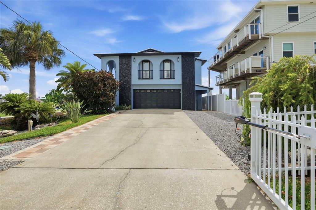 A two-story house with a dark stone facade, a two-car garage, and a concrete driveway — 3420 EAGLE NEST DRIVE, HERNANDO BEACH, FL