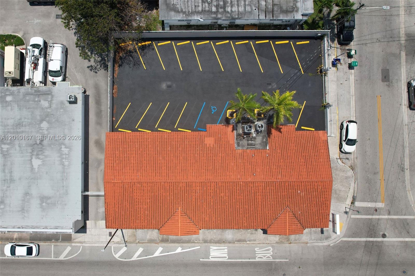 An aerial view shows a building with a red tile roof and an adjacent parking lot — 1888 NW 7th St, Miami FL 33125, MIAMI, FL
