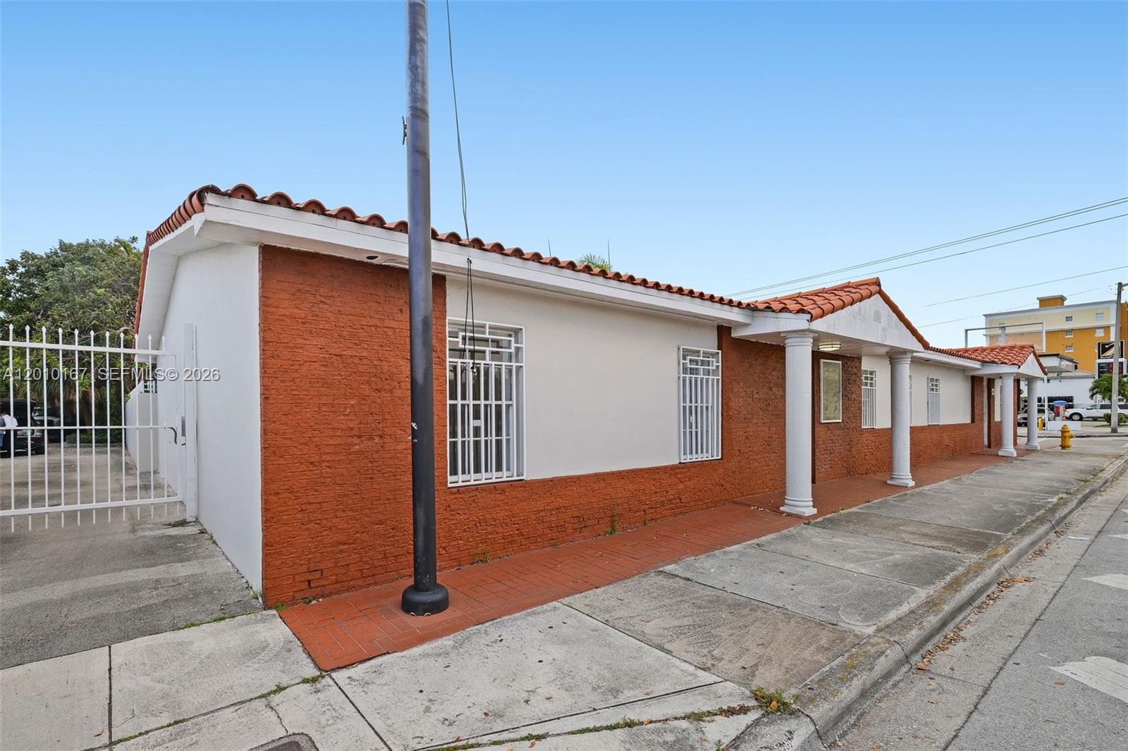 A single-story building features red brick walls, white stucco accents, and a tiled roof — 1888 NW 7th St, Miami FL 33125, MIAMI, FL