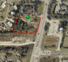 This is an aerial map view showing a vacant, tree-covered lot outlined in red — 2595 S VOLUSIA AVENUE, ORANGE CITY, FL