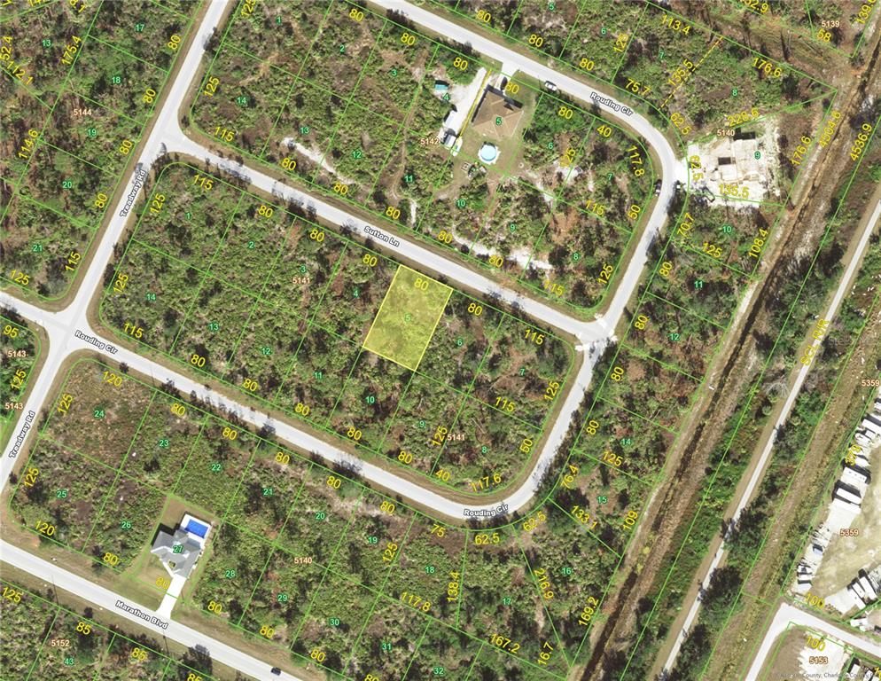 This is an aerial map showing a highlighted vacant residential lot within a suburban neighborhood — 7365 SUTTON LANE, PORT CHARLOTTE, FL