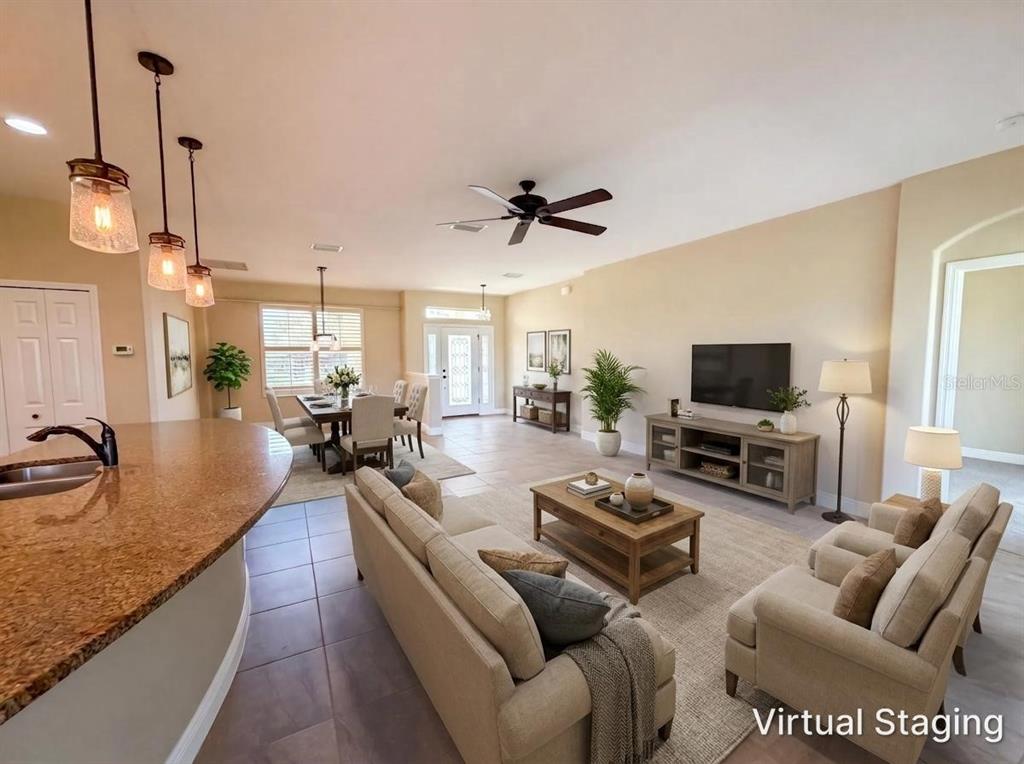 A living room and dining area feature tile flooring, neutral walls, and virtual staging furniture — 27103 CAMERONS RUN, LEESBURG, FL