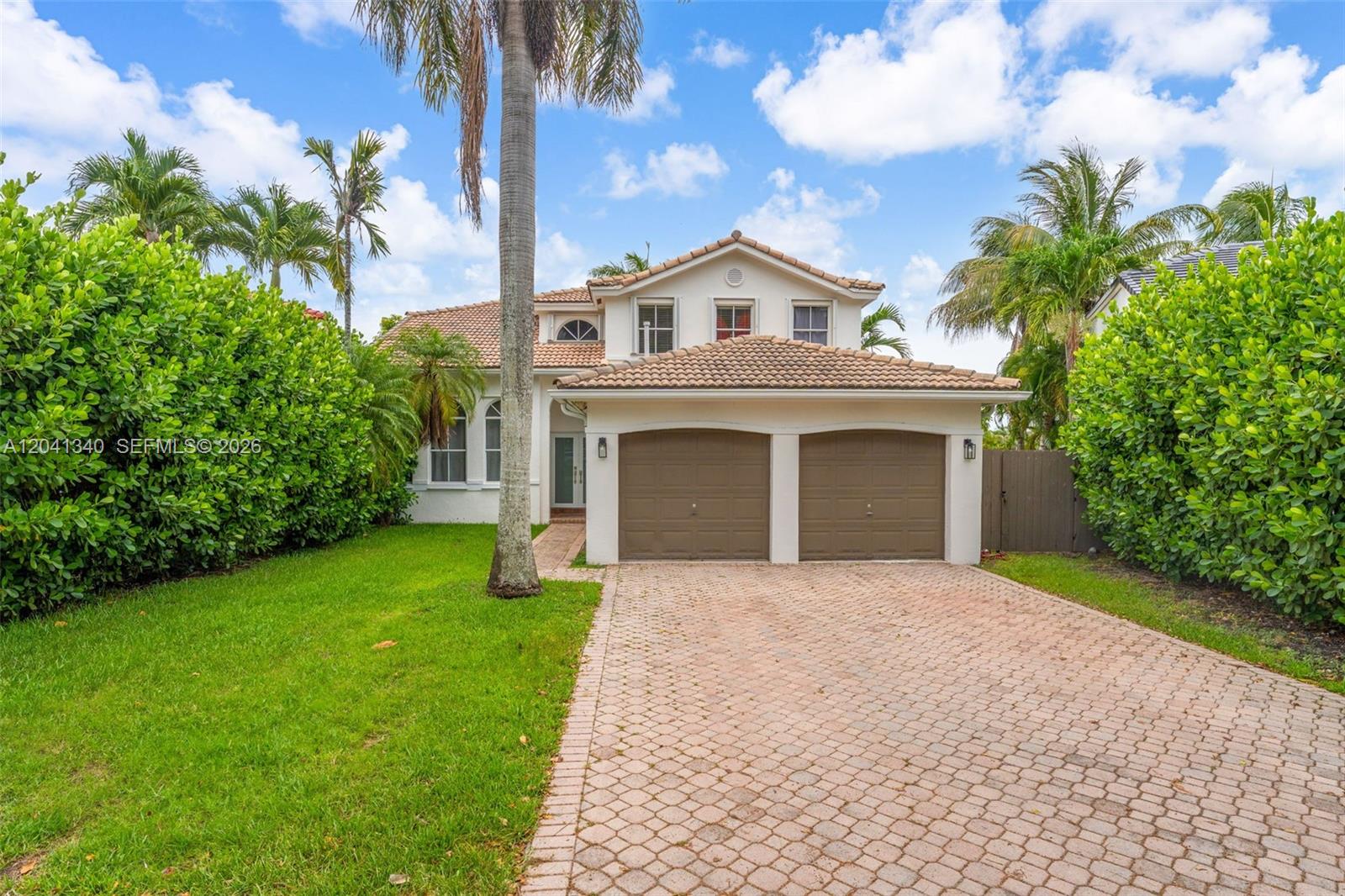 A two-story house with a two-car garage, a paved driveway, and lush landscaping — 16335 SW 81 St, Miami FL 33193, MIAMI, FL