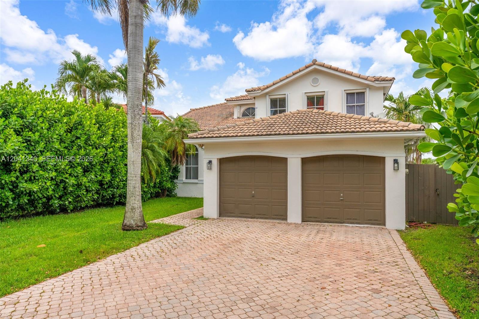 A two-story house features a two-car garage, a paved driveway, and lush landscaping — 16335 SW 81 St, Miami FL 33193, MIAMI, FL