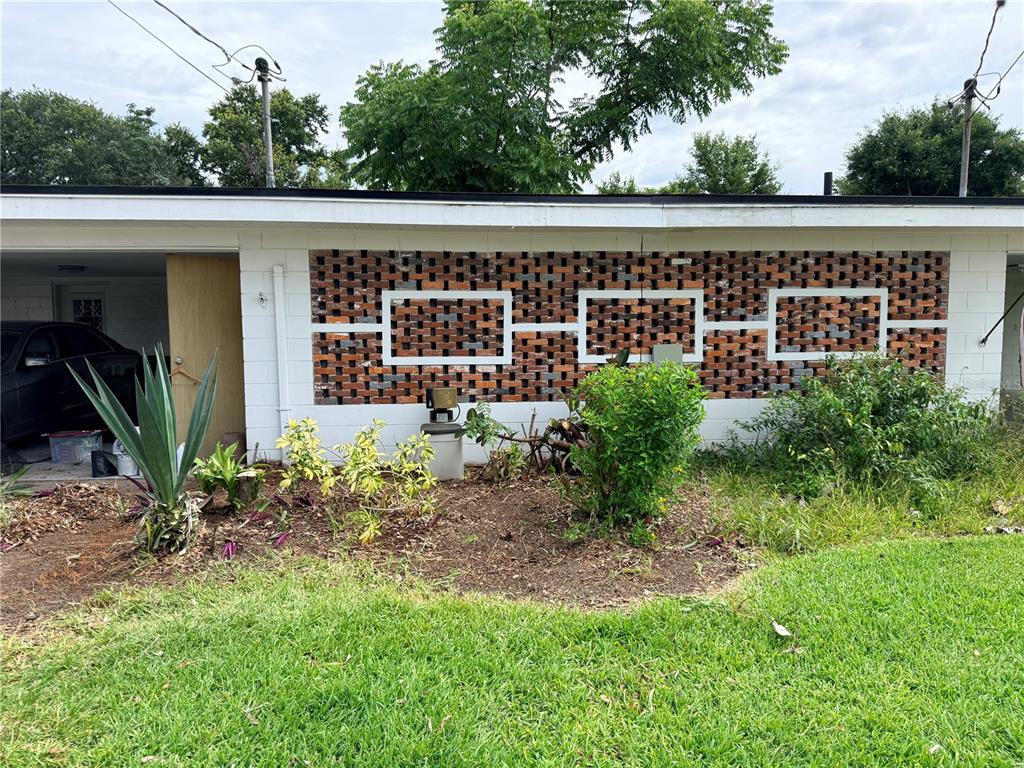 A white exterior wall features a decorative brick screen with three rectangular framed openings — 719 AVENUE Q SE, WINTER HAVEN, FL
