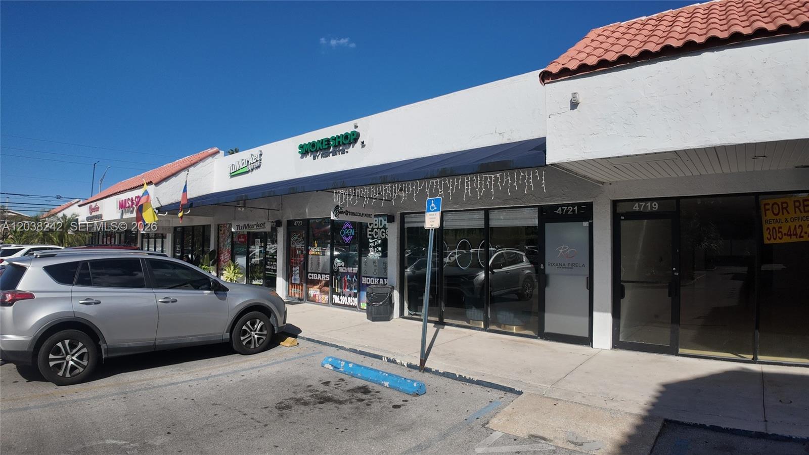 A row of commercial storefronts features a parking lot in the foreground under a clear sky — 4721 NW 79th Ave, Doral FL 33166, DORAL, FL