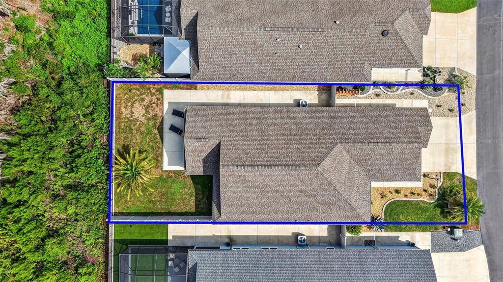 An aerial view shows a residential house with a fenced backyard and a concrete patio — 4686 HILES PLACE, THE VILLAGES, FL
