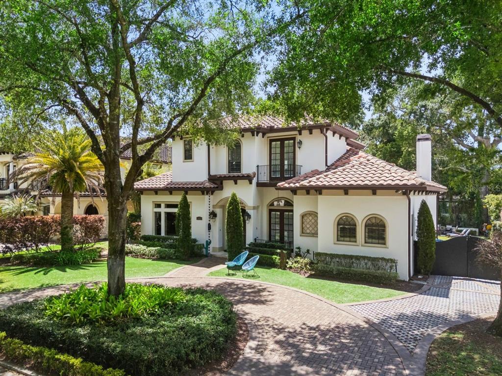 A two-story stucco house with a tile roof and a circular brick driveway — 1864 GRINNELL TERRACE, WINTER PARK, FL