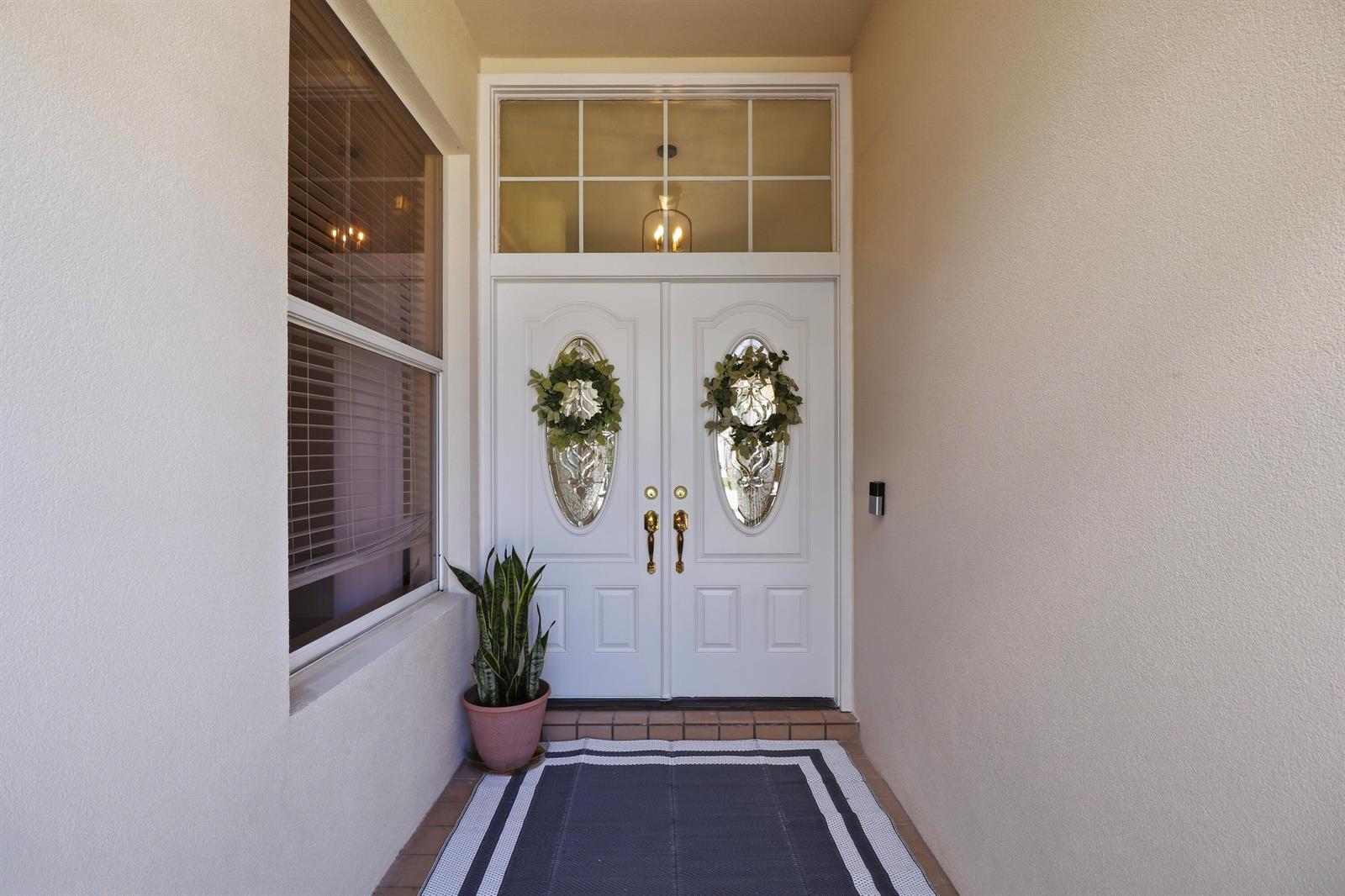 A front entryway features white double doors with glass inserts, a transom window, and a plant — 7756 SE Bay Cedar Circle, Hobe Sound FL 33455, HOBE SOUND, FL