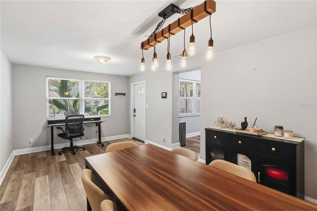 A dining room features a wooden table, a linear pendant light, and a desk area — 7012 40TH AVENUE N, ST PETERSBURG, FL