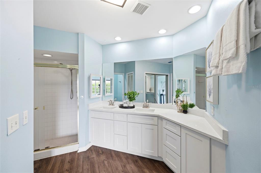 A bathroom features a double vanity with white cabinets, a quartz countertop, and a shower — 11541 SHIPWATCH DRIVE UNIT 1011, LARGO, FL