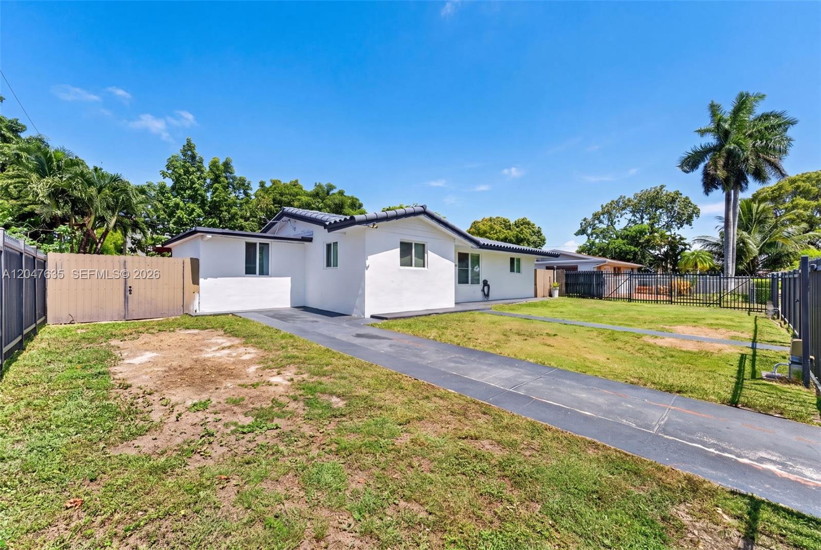 A white single-story house with a dark roof and a paved driveway sits on grass — 17841 SW 112th Pl, Miami FL 33157, MIAMI, FL