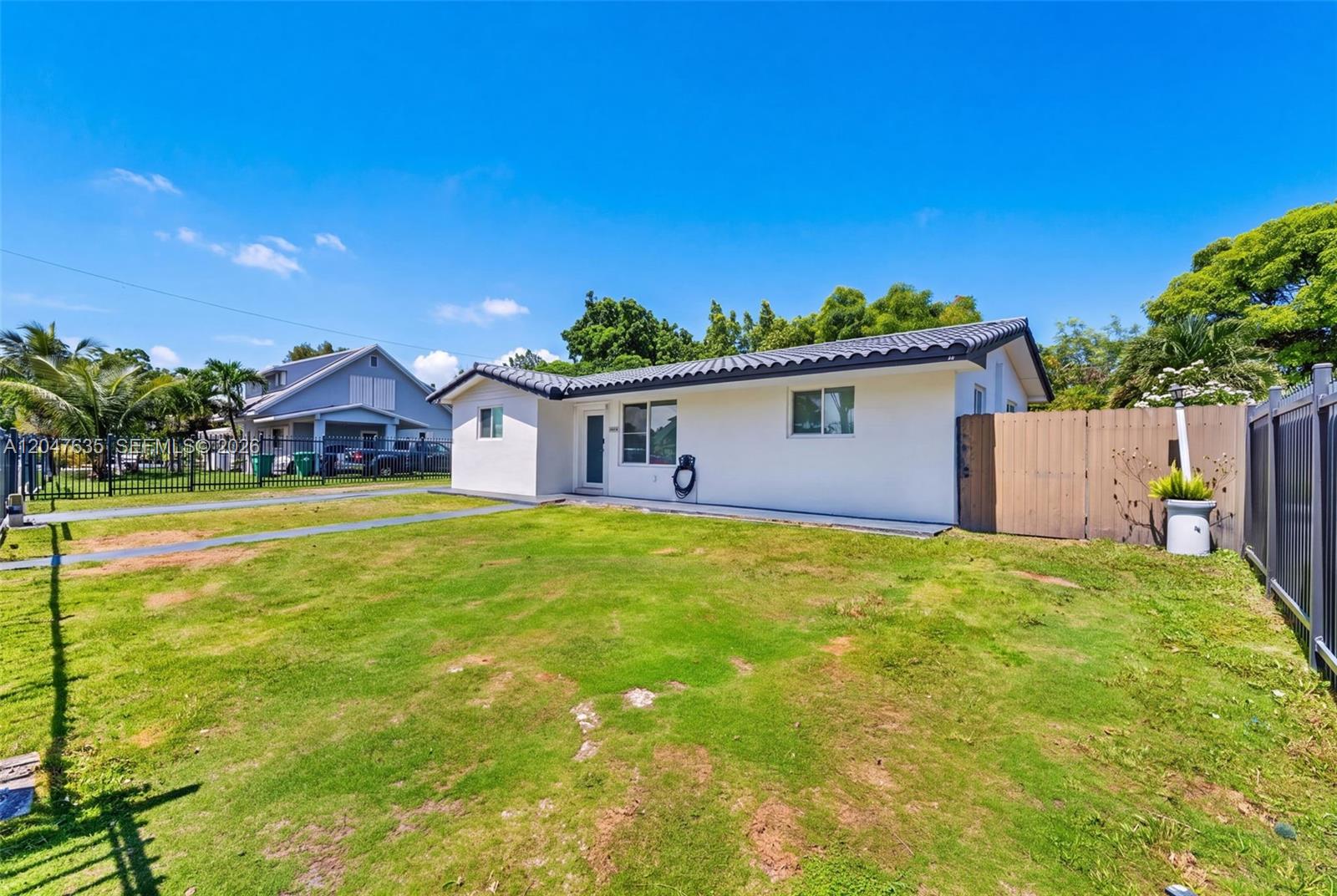 A white single-story house with a dark tiled roof sits on a grassy lot — 17841 SW 112th Pl, Miami FL 33157, MIAMI, FL