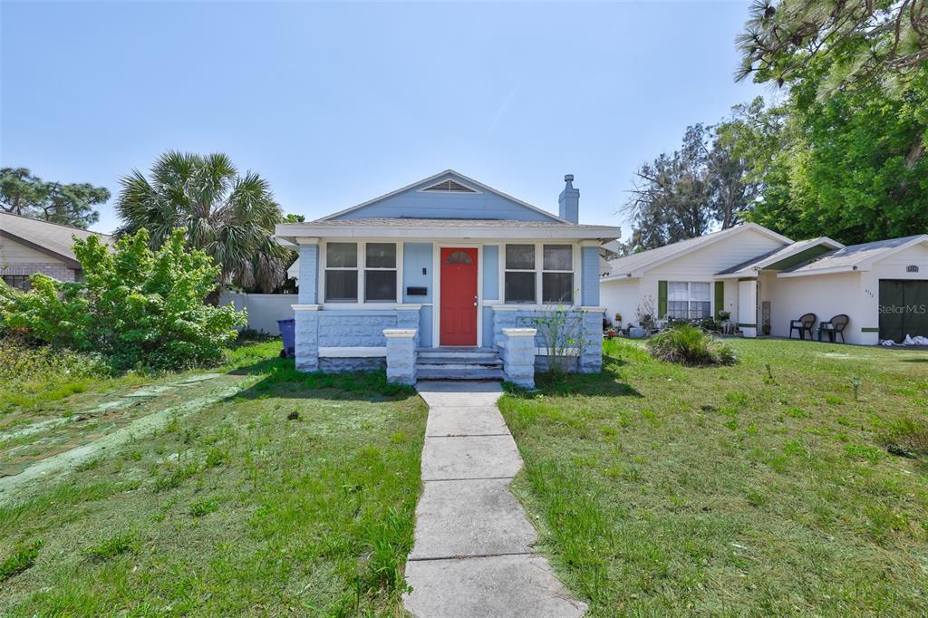 A light blue single-story house with a red front door and a concrete walkway — 4736 5TH AVENUE S, ST PETERSBURG, FL