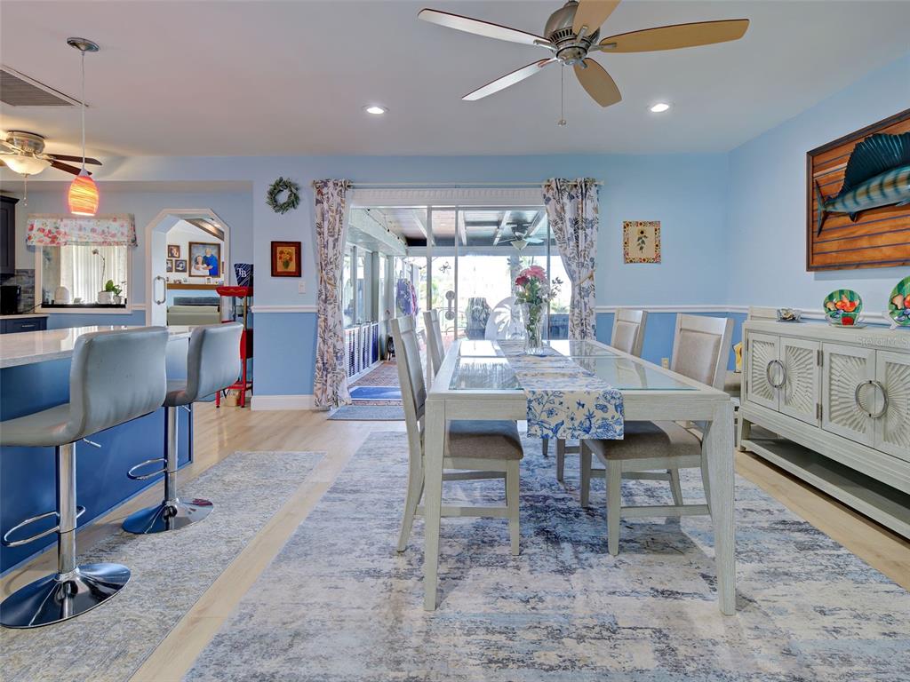 A dining area with a glass-top table, blue walls, and a view of a patio — 107 PECKHAM STREET SW, PORT CHARLOTTE, FL