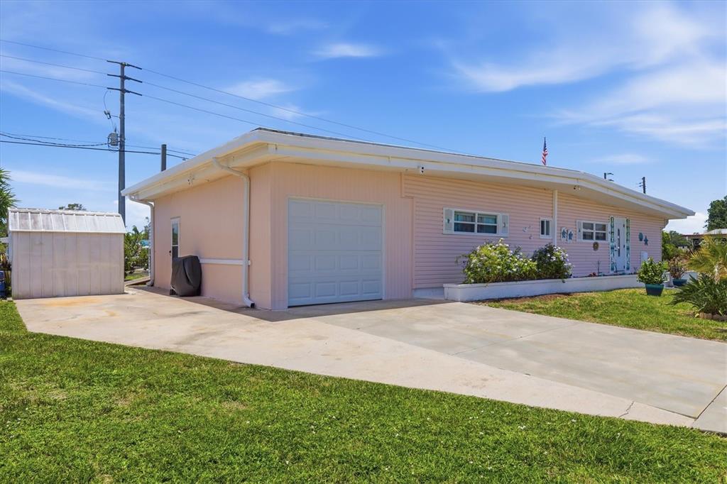 A light pink single-story house with a garage, driveway, and a detached white shed — 1006 42ND AVENUE DRIVE E, ELLENTON, FL