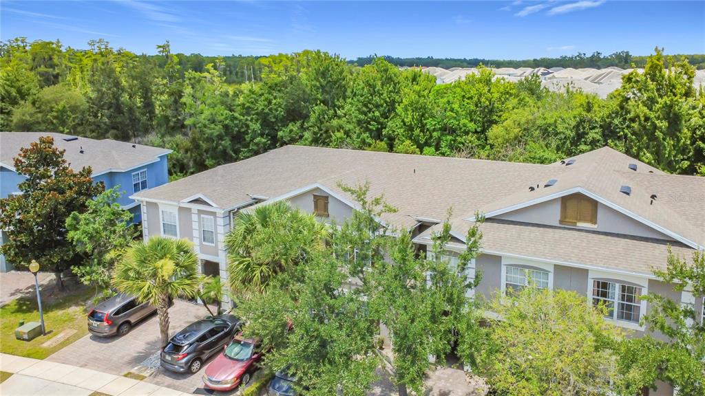 An aerial view shows a multi-story residential building with a shingled roof and parking — 2394 CARAVELLE CIRCLE, KISSIMMEE, FL