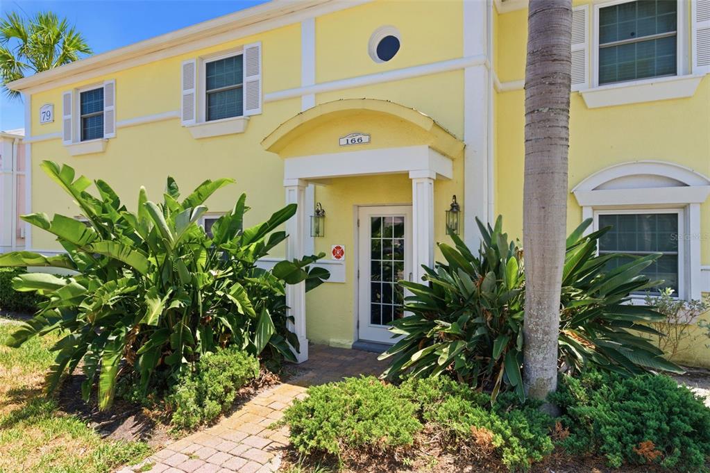 A yellow two-story building exterior features a covered entryway with a glass-paned door — 144-166 POMPANO DRIVE SE UNIT A, ST PETERSBURG, FL