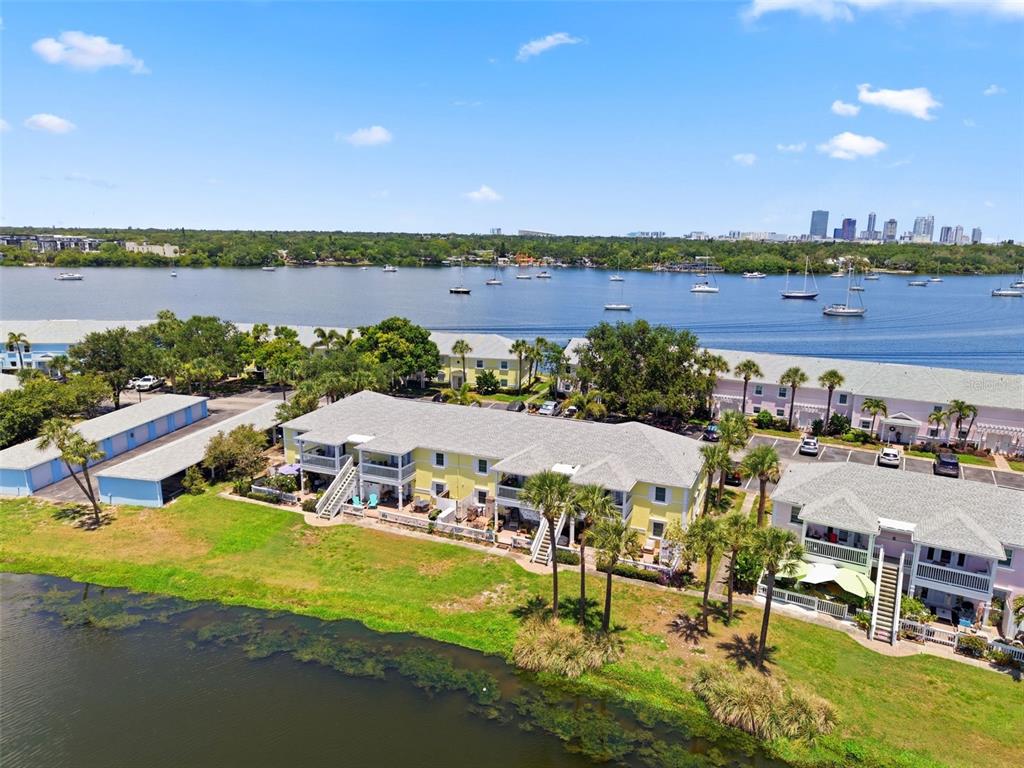 An aerial view shows multi-story apartment buildings near a body of water with sailboats — 144-166 POMPANO DRIVE SE UNIT A, ST PETERSBURG, FL