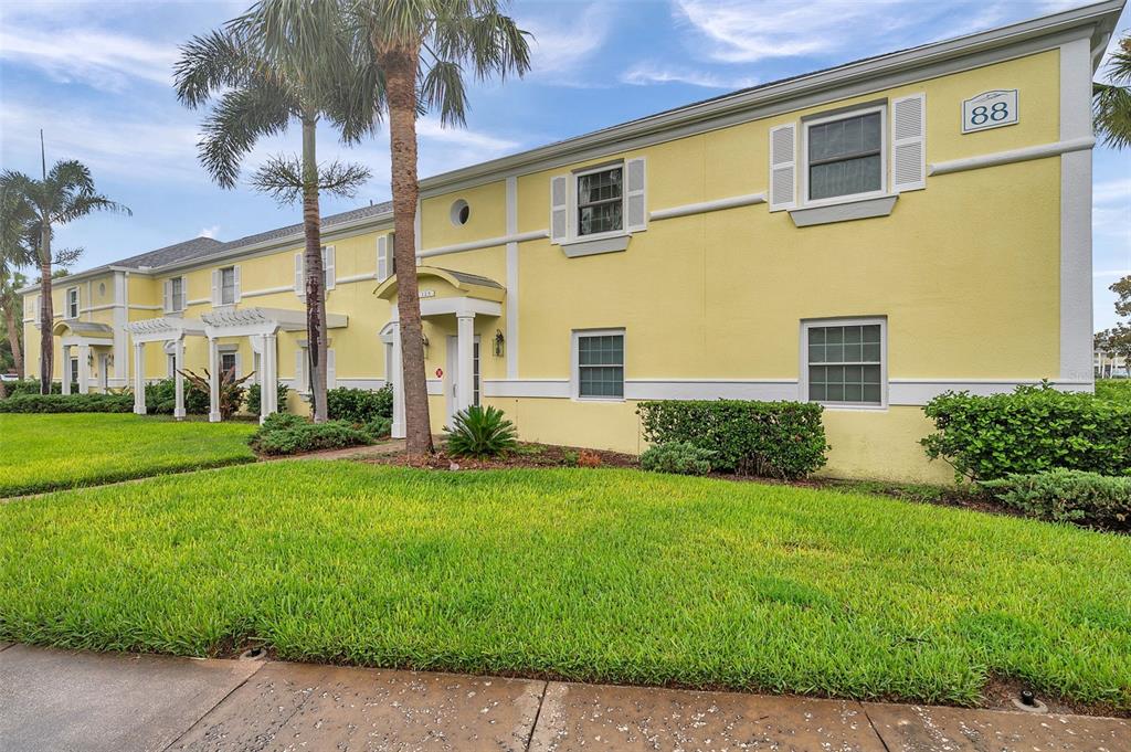 A two-story yellow apartment building with white trim and a palm tree in front — 144-166 POMPANO DRIVE SE UNIT A, ST PETERSBURG, FL