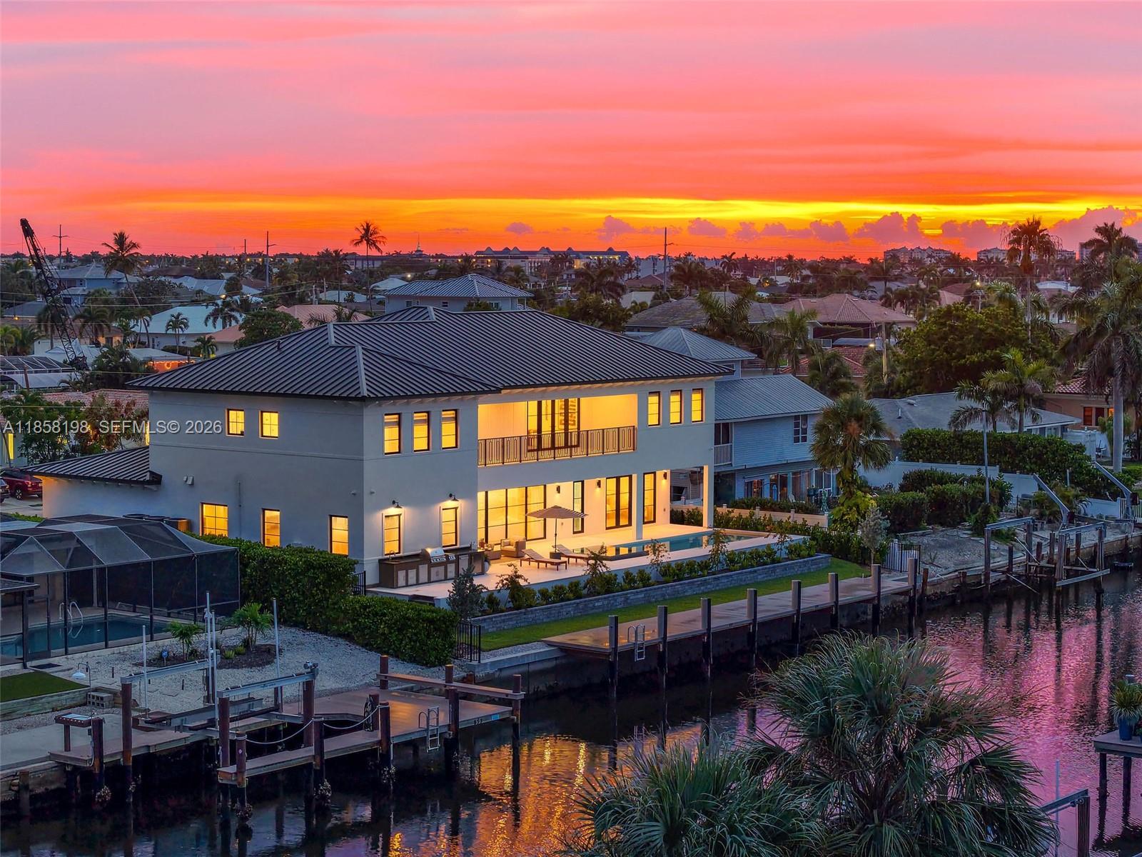 An aerial view of a modern two-story waterfront home with a pool at sunset — 839 Chestnut CT, Marco Island FL 34145, MARCO ISLAND, FL