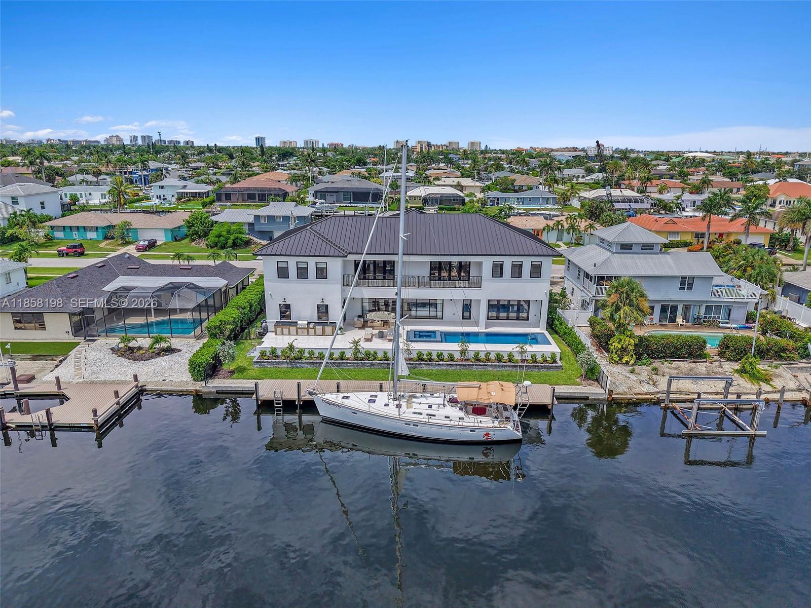 An aerial view shows a two-story white house with a dark roof, pool, and sailboat — 839 Chestnut CT, Marco Island FL 34145, MARCO ISLAND, FL
