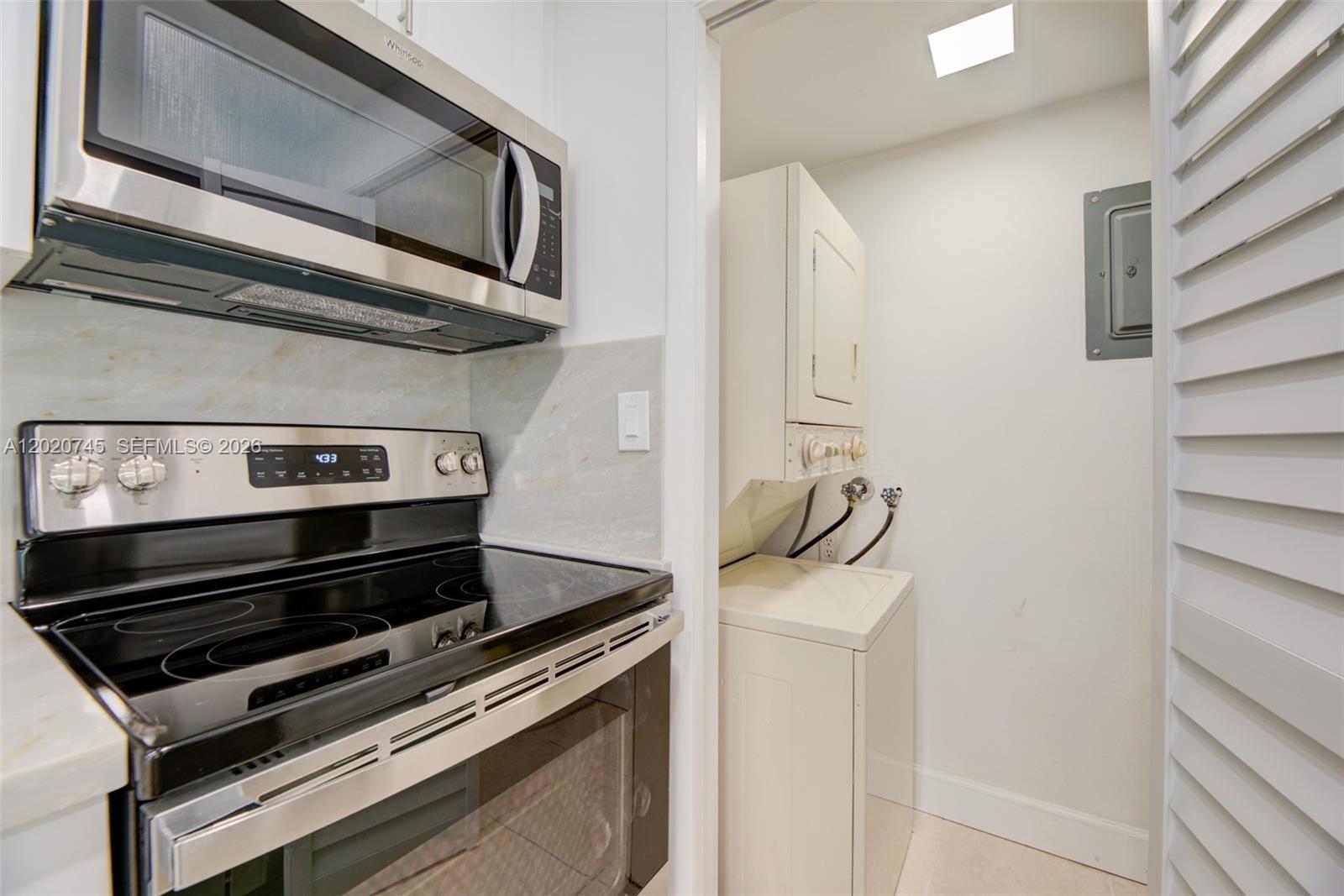 A kitchen with a stainless steel stove and microwave next to a laundry closet — 200 LAKEVIEW DR # 211, Weston FL 33326, WESTON, FL