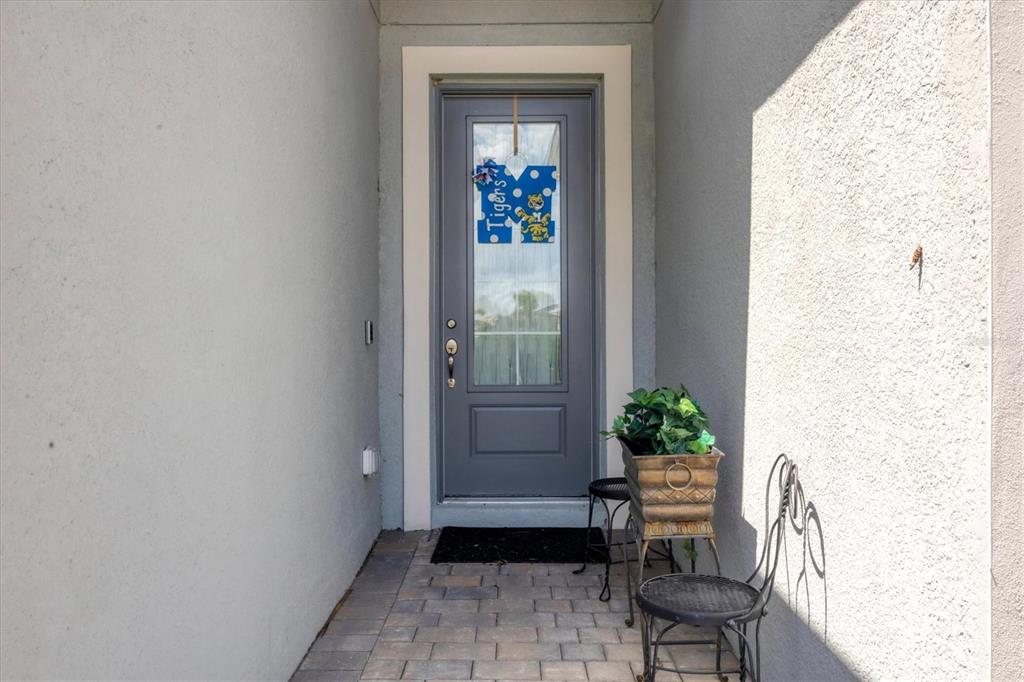 A gray front door with a glass insert is set within a recessed entryway — 14589 PONCE DE LEON TRAIL, PORT CHARLOTTE, FL