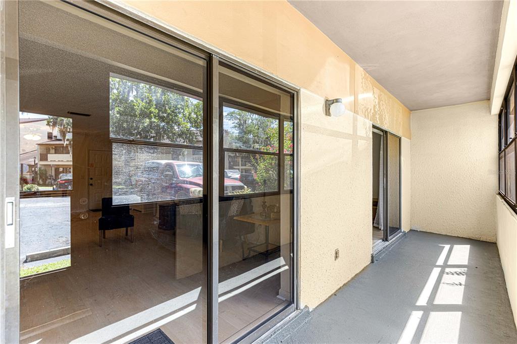 A covered patio with a concrete floor and sliding glass doors leading into a home — 3507 E FORT KING STREET UNIT 129, OCALA, FL