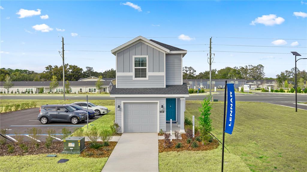 A two-story, light blue house with a single-car garage and a teal front door — 9199 SW 91ST COURT, OCALA, FL