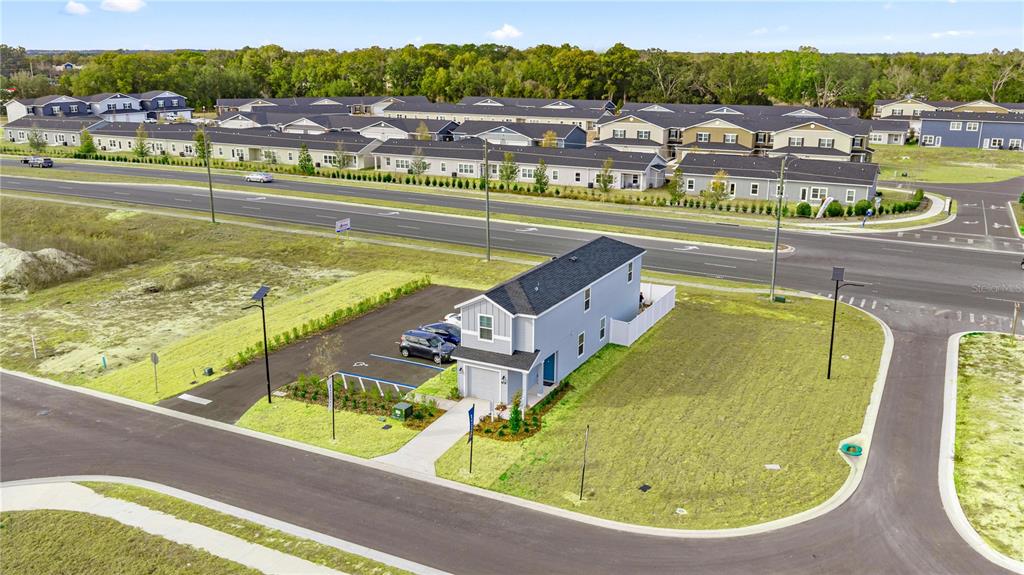 An aerial view shows a detached house with a parking lot next to a road — 9199 SW 91ST COURT, OCALA, FL